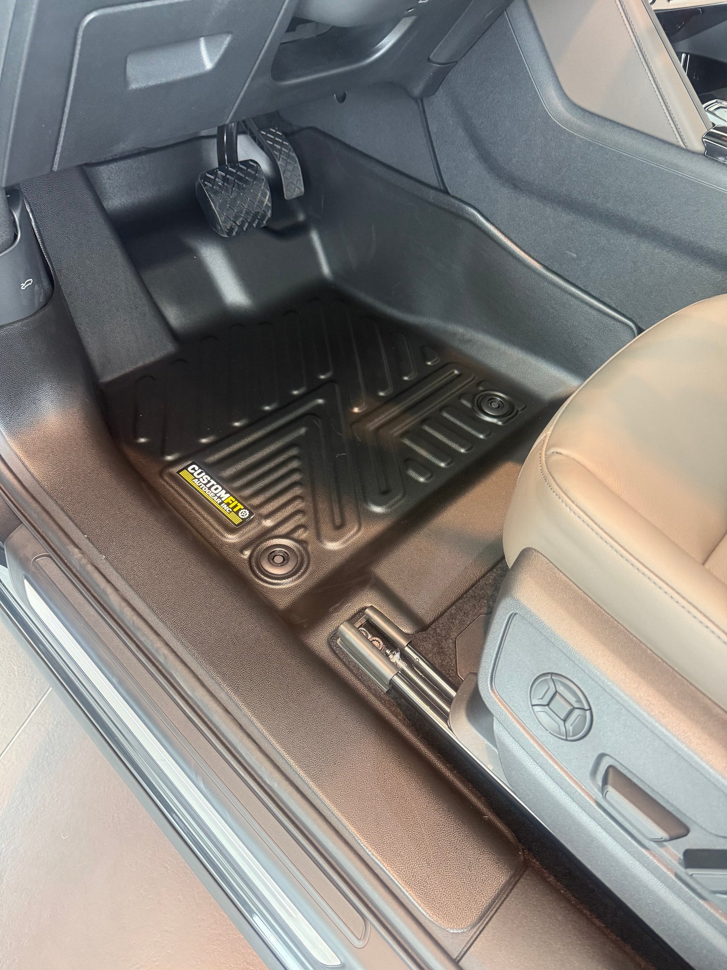 Audi Q5 Car interior with black floor mats and a visible brand logo.