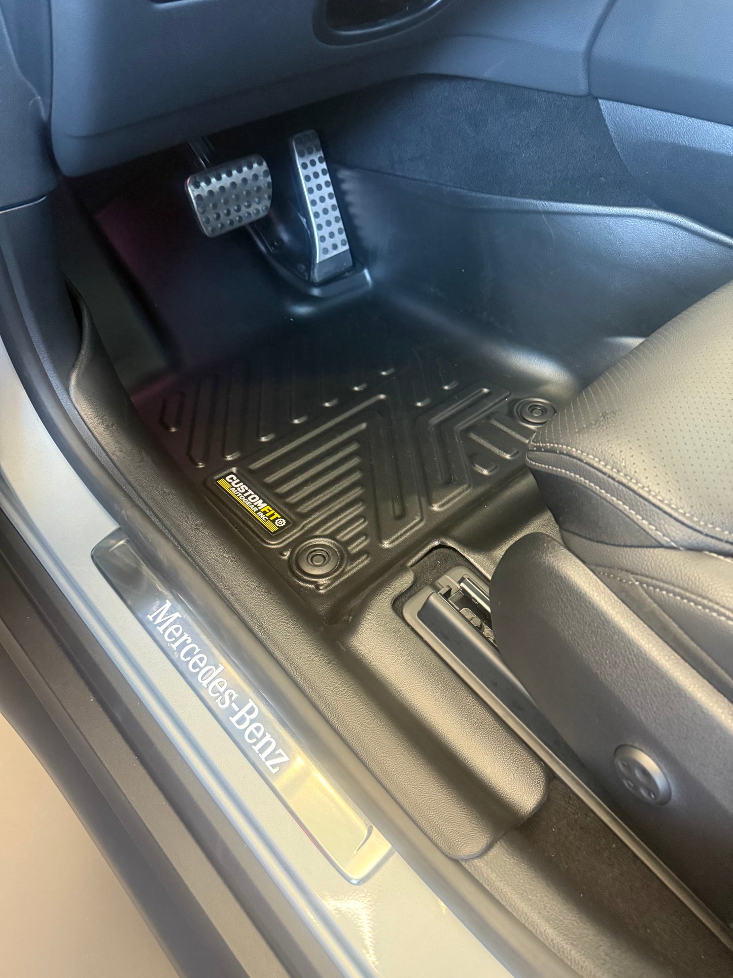 Mercedes Benz GLC 300 Car interior with a focus on the floor mat and door panel, featuring Mercedes-Benz branding.