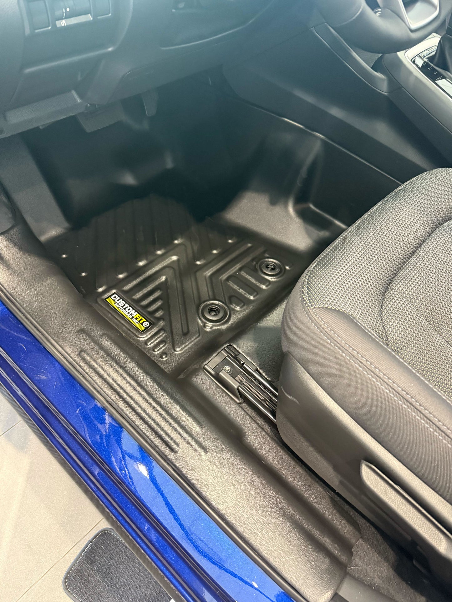 Subura Crosstrek car interior with a black floor mat featuring a logo on the driver's side.