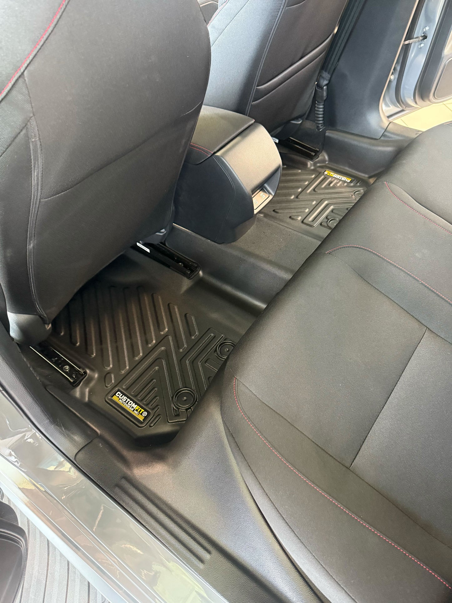 Honda civic hybrid car interior with black floor mats and visible brand logo.