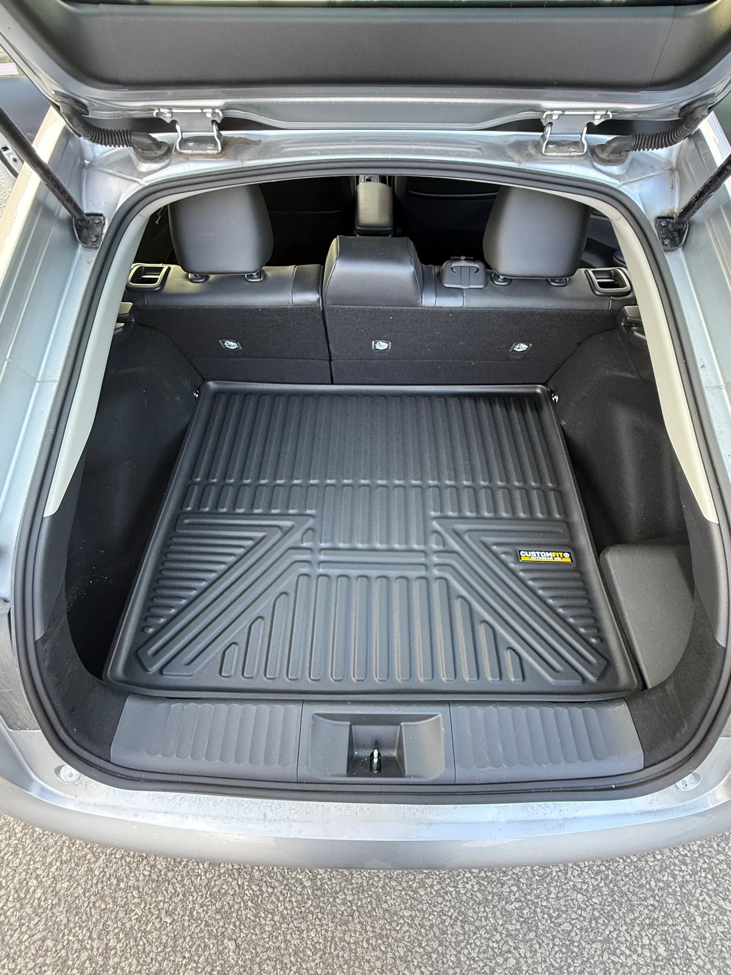 Toyota Prius Car trunk with a black cargo mat and visible brand logo.